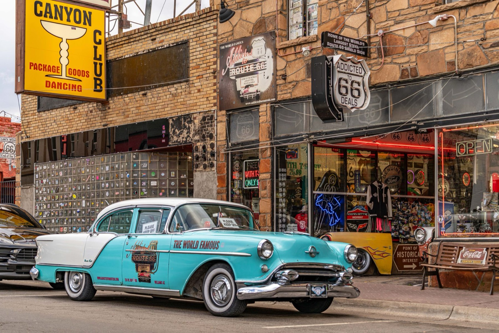 Vintage turquoise car parked outside a Route 66 shop in Williams